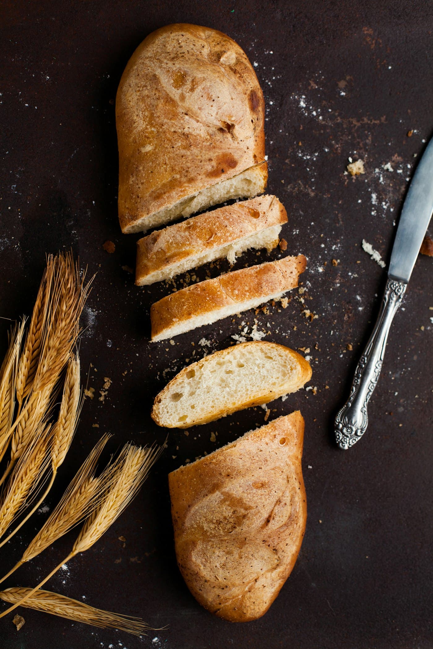 Sliced sourdough with an open crumb beside a bread knife.