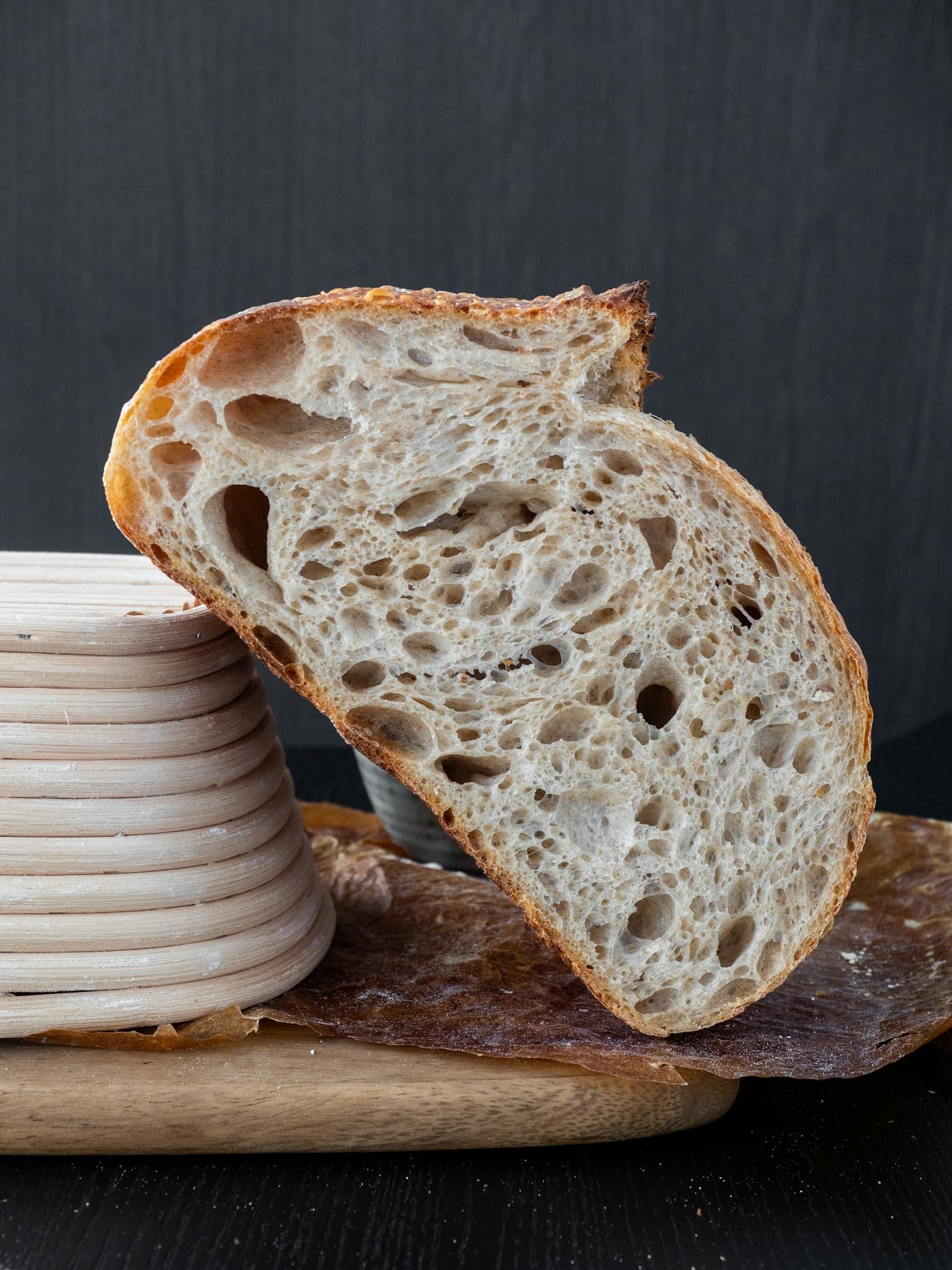 A rustic round loaf dusted with flour on a wooden peel.