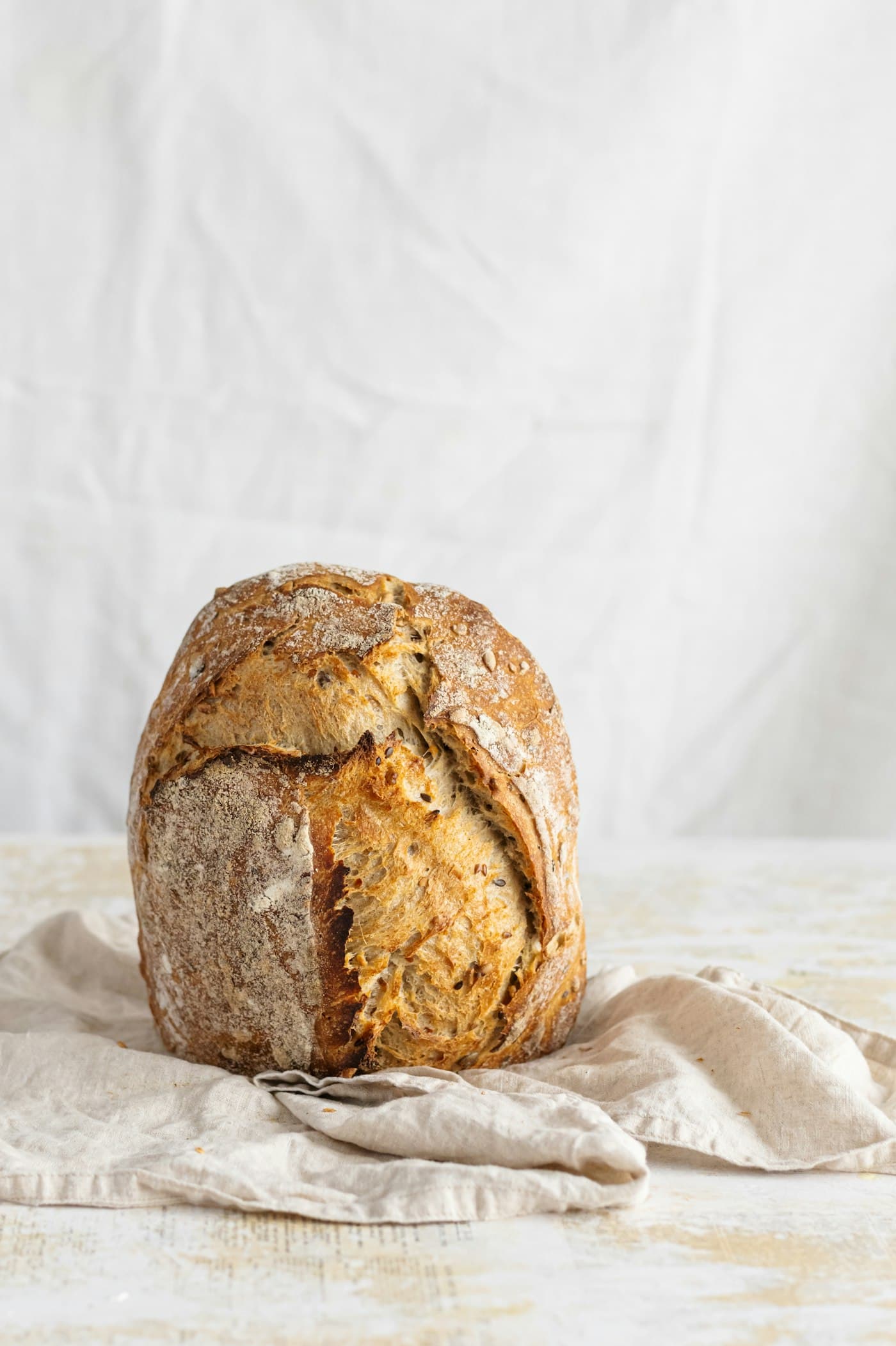 A golden-brown loaf resting on a linen cloth.